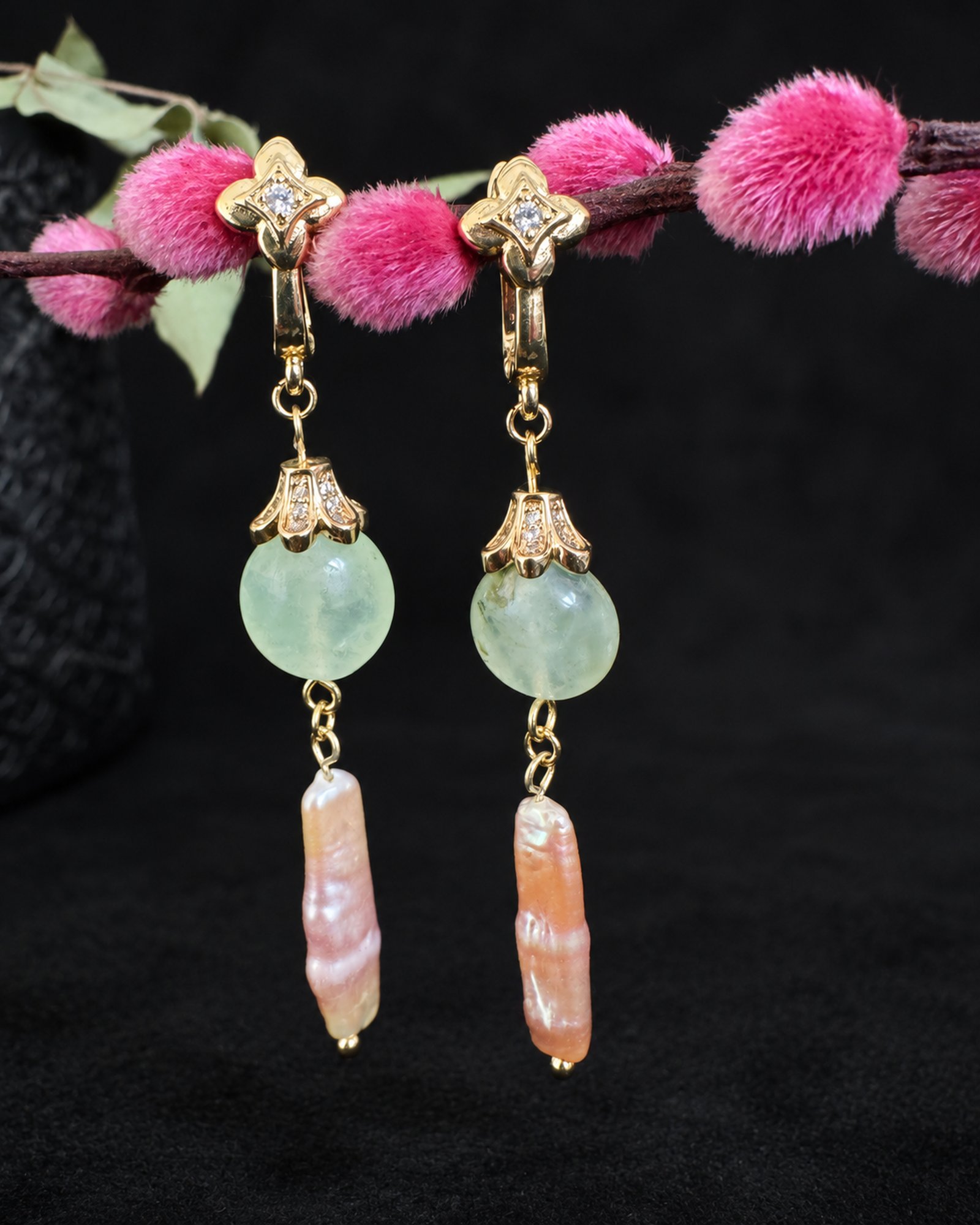 Pair of hanging earrings with pale green round beads, elongated blush-pink drops and gold-coloured decorative fastenings.