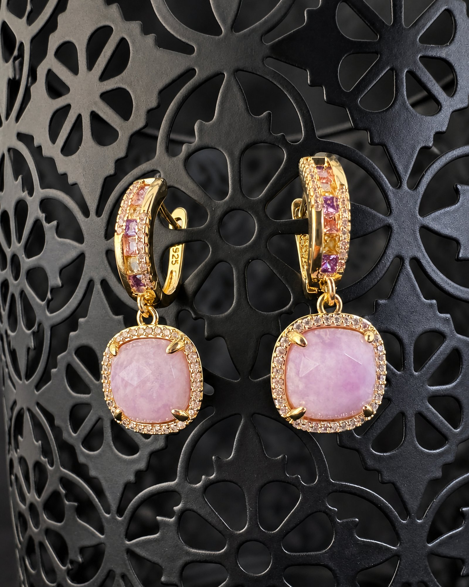 Pale lavender drop earrings on a black patterned support, showing the hoops from different angles.