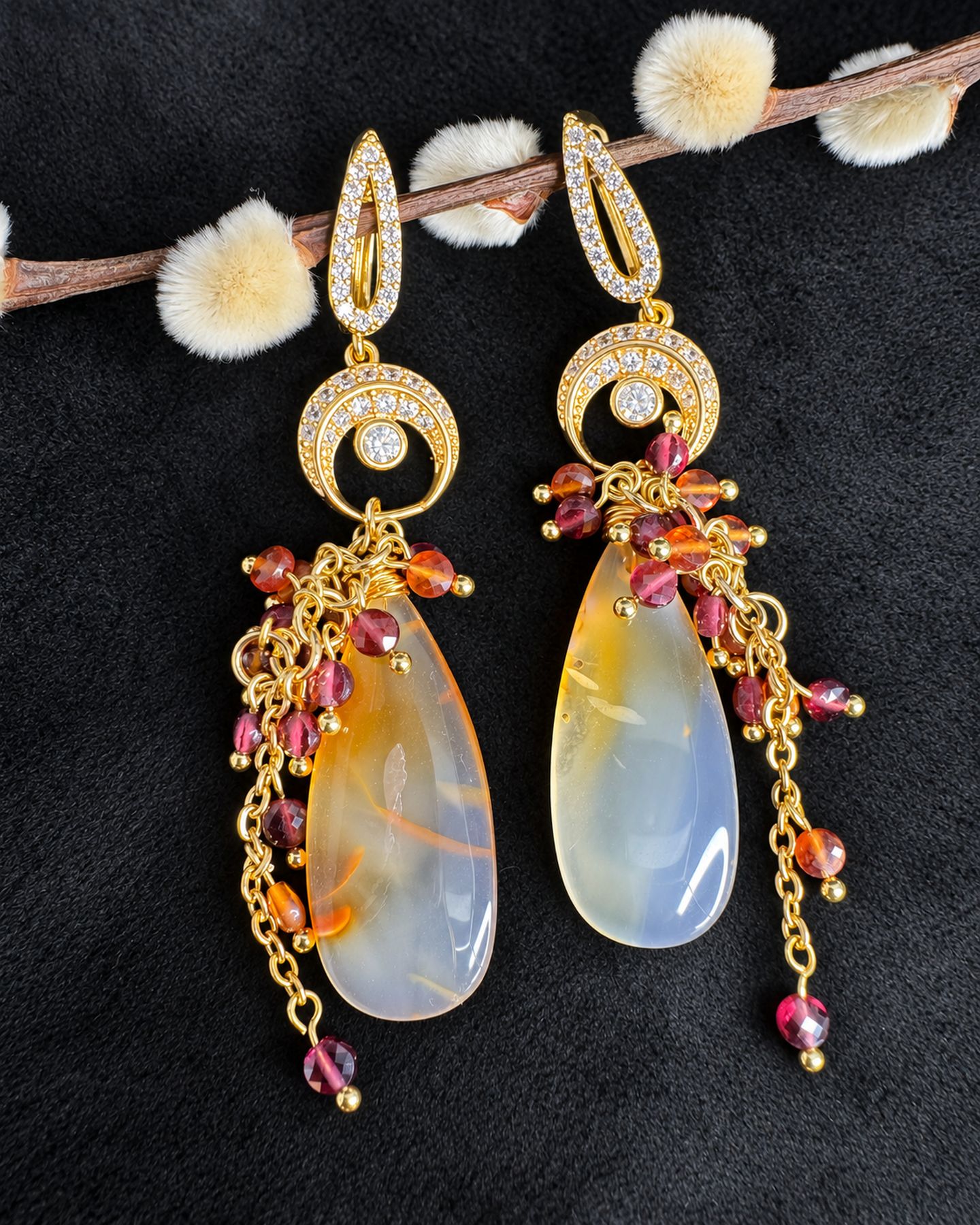 Pair of drop earrings hanging from a budding branch, with gold-toned circular connectors, pink and orange bead clusters and translucent teardrops.