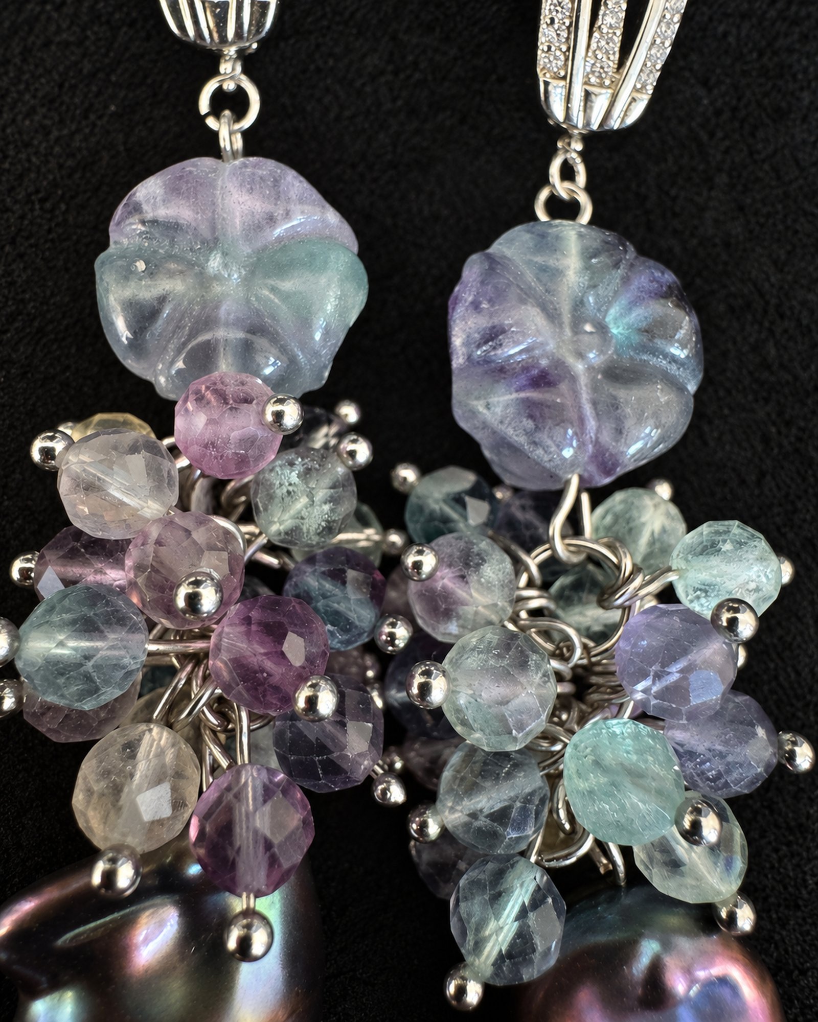 Close-up of pale lavender and mint beads, carved upper shapes and silver-toned connecting details.