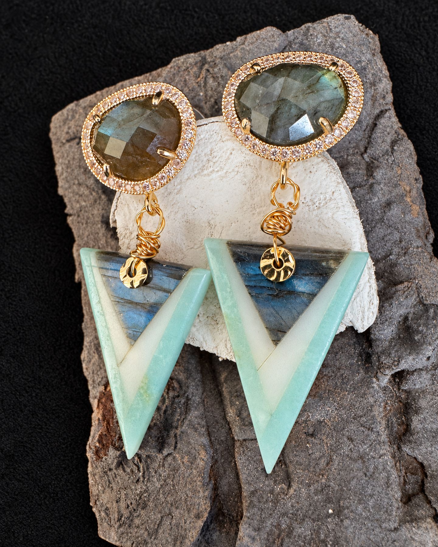 Pair of earrings with smoky oval tops, gold-toned links and mint-and-ivory triangular drops resting on a textured support.